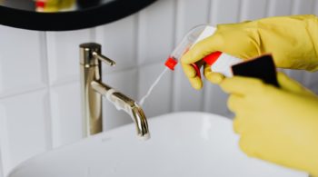 faceless cleaner in gloves tiding up bathroom